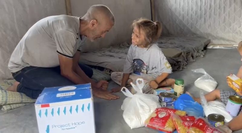 A Project Hope volunteer delivering supplies to a family with young children