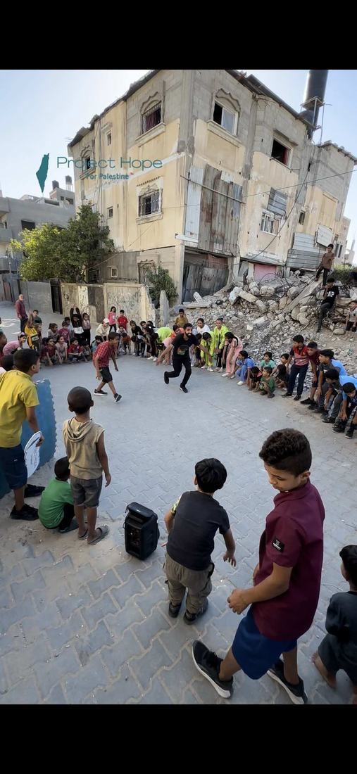 Children gather for a performance among the ruins.