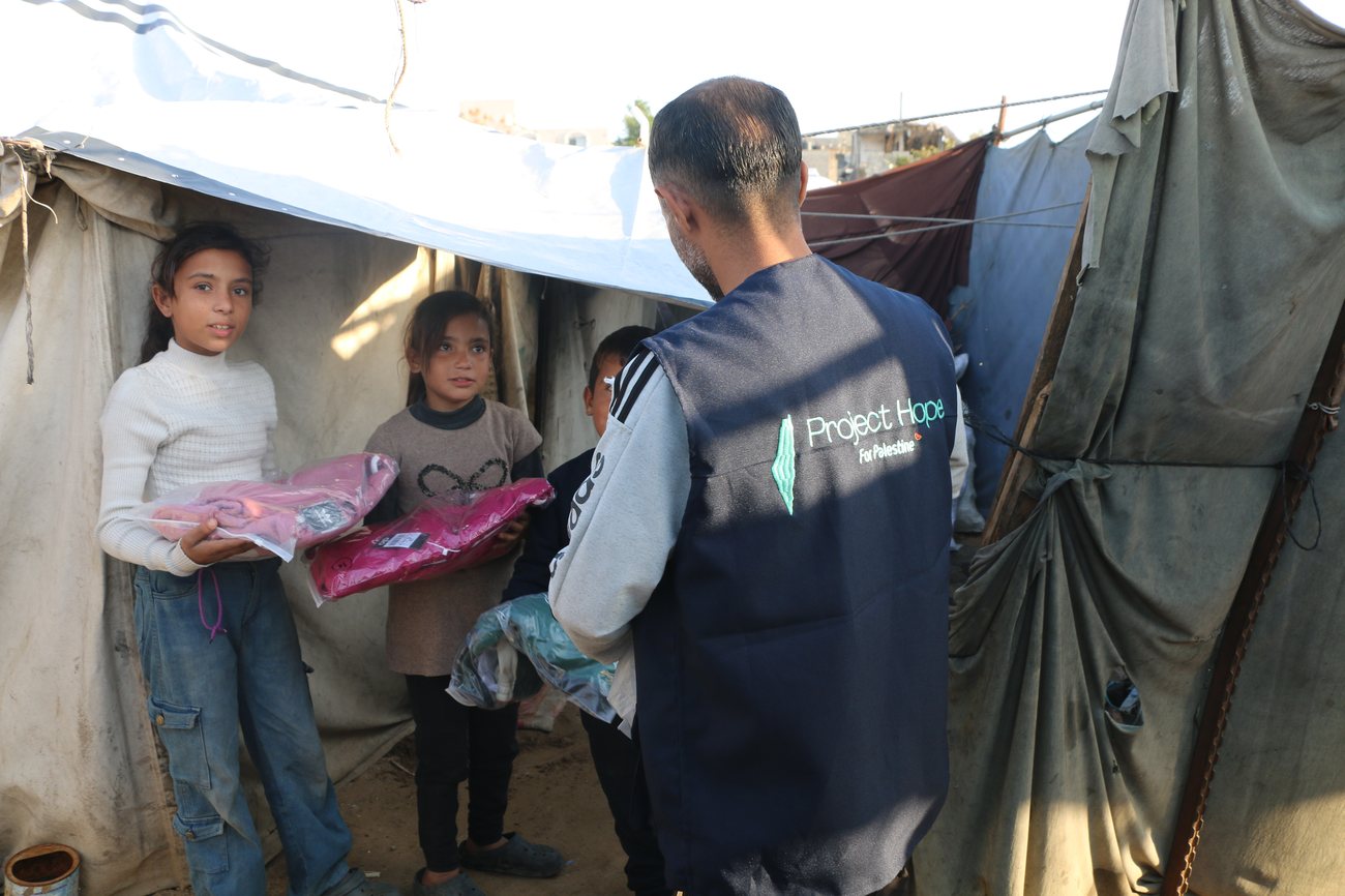 Children receiving new clothes at a distribution in a displacement camp.